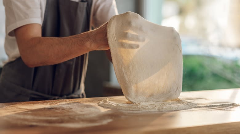 Chef stretching out dough