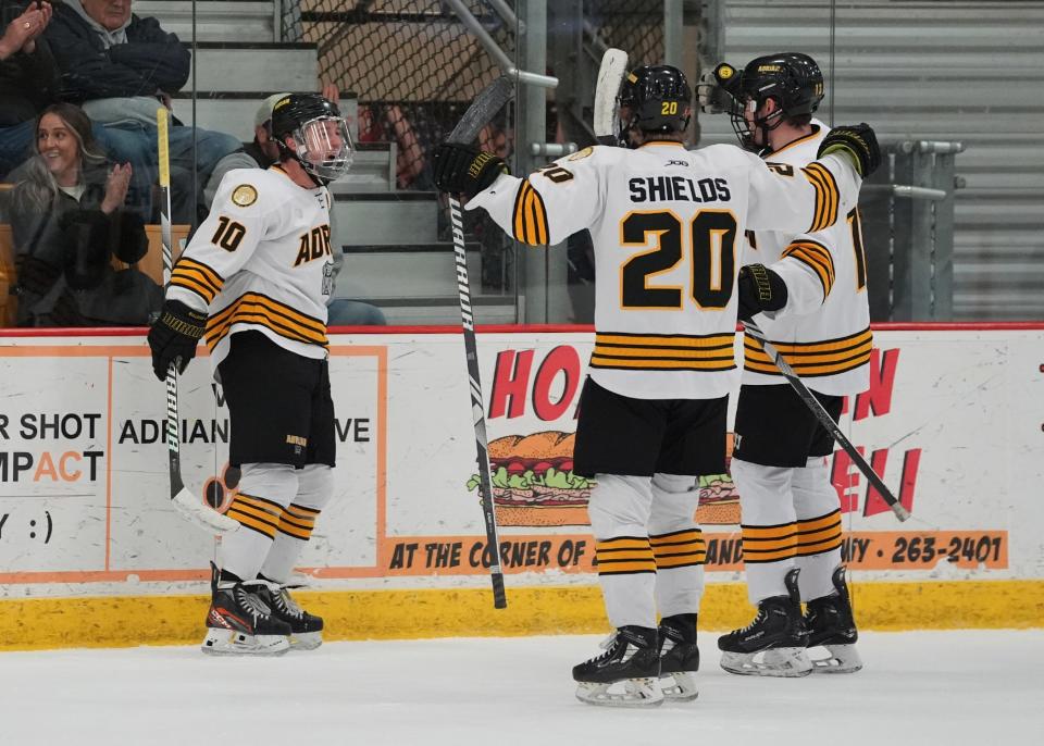 Adrian College's Zachary Heintz (left), Jaden Shields and Jacob Suede (back) celebrate a goal during Saturday's NCHA semifinal against Aurora