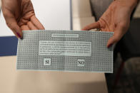 A woman shows her ballot for the abortion referendum at a polling station in San Marino, Sunday, Sept. 26, 2021. Tiny San Marino is one of the last countries in Europe which forbids abortion in any circumstance — a ban that dates from 1865. Its citizens are voting Sunday in a referendum calling for abortion to be made legal in the first 12 weeks of pregnancy. (AP Photo/Antonio Calanni)