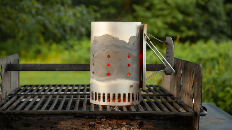 A charcoal chimney on a grill