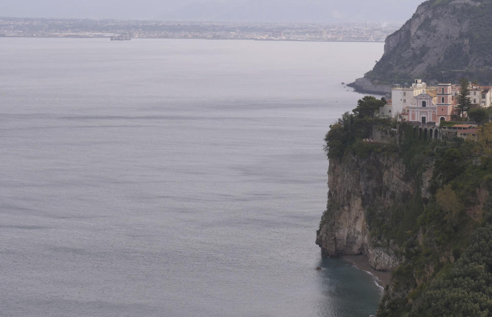 In this photo taken on Sunday May 3, 2020, a view of the town of Vico Equense overlooking the Gulf of Naples, Italy. Preliminary results from a survey of seawater quality during Italy’s coronavirus lockdown indicate a sharp reduction in pollution from human and livestock waste in the seas off Rome. Authorities stressed it was too soon to give the lockdown sole credit for the change. They say shifting sea currents and limited rainfall in April and May also could have reduced runoff from agriculture. (AP Photo/Paolo Santalucia)