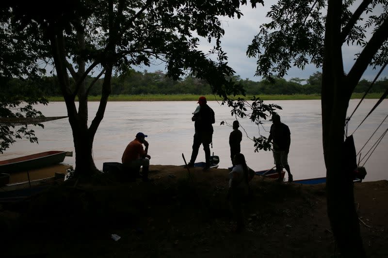 Venezuelan migrants are seen on the banks of the Arauca river after fleeing their country due to military operations, according to the Colombian migration agency, in Arauquita