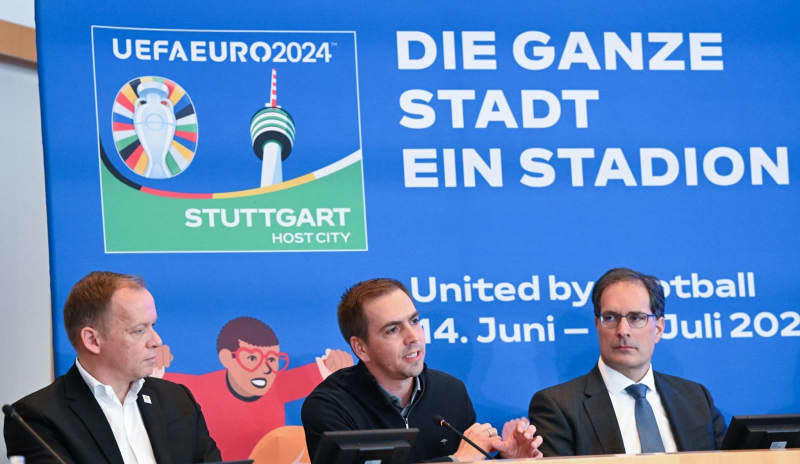 (L-R) Markus Stenger, Managing Director of EURO 2024 GmbH, Philipp Lahm, Tournament Director of the European Football Championship 2024 and Clemens Maier, the sports mayor of Stuttgart, sit on the podium in front of the Stuttgart logo of the European Championship at a press conference in the town hall. Bernd Weißbrod/dpa