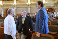 In this Thursday, June 4, 2020, photo, Kansas House Minority Leader Tom Sawyer, right, D-Wichita, confers with House Majority Leader Dan Hawkins, center, R-Wichita, and House Speaker Ron Ryckman Jr., left, R-Olathe, during a break at in the chamber's work during a special legislative session on the coronavirus pandemic at the Statehouse in Topeka, Kan. Most Democratic lawmakers wore masks, while most Republicans did not. The issue is one of many creating a partisan divide in state legislatures across the U.S. (AP Photo/John Hanna)