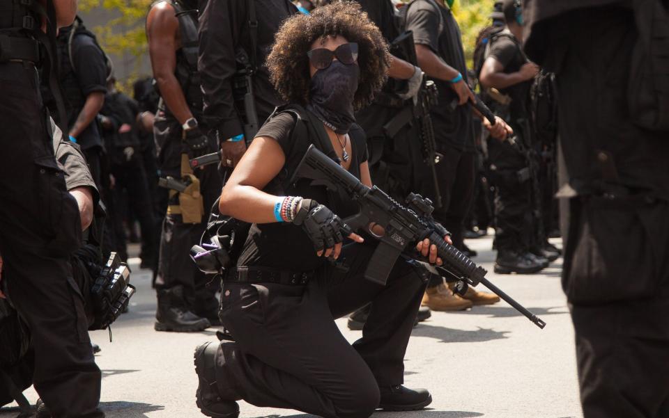 A female member from the Not F****** Around Coalition (NFAC) kneels in Kentucky during a protest for Breonna Taylor, shot dead by police in her apartment - Leslie Spurlock/ZUMA Wire/Shutterstock/Shutterstock