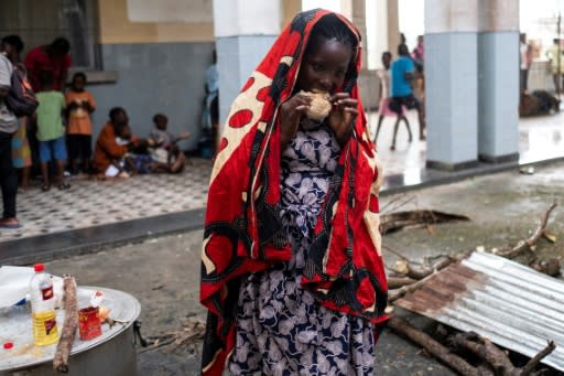 A woman eats at an emergency foodbank in Beira, Mozambique