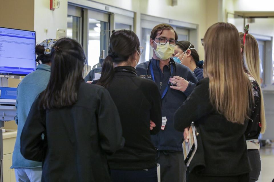 Dr. Curtis Converse, center, confers with nurses on his morning rounds in the ICU at Arrowhead Regional Medical Center