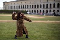 A fan wearing an animal print coat throws a football outside the stadium before the football game between Harvard and Yale Universities at Harvard in Cambridge, Massachusetts November 22, 2014. Known as "The Game," the first Harvard versus Yale football game was played in 1875, making it one of the oldest rivalries in college sports. REUTERS/Brian Snyder (UNITED STATES - Tags: EDUCATION SPORT SOCIETY FOOTBALL)