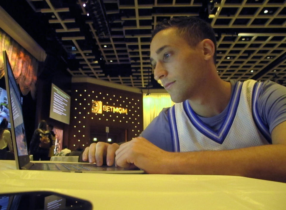 Jonathan Price of New York researches picks for the March Madness college basketball championship tournament on Friday March 19, 2021 at the Borgata casino in Atlantic City, NJ. Hugely disappointed when last year's tournament was canceled due to the coronavirus outbreak, Price says, "We're owed a March." (AP Photo/Wayne Parry)