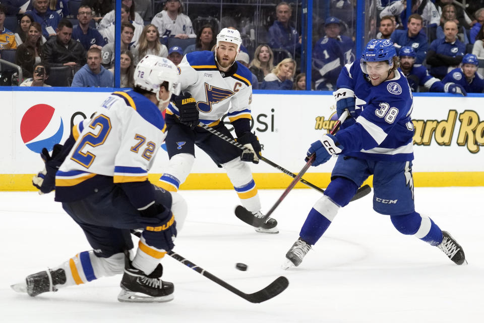 Tampa Bay Lightning left wing Brandon Hagel (38) fires the puck past St. Louis Blues defenseman Justin Faulk (72) and goaltender Jordan Binnington (not shown) for a goal during the second period of an NHL hockey game Friday, Nov. 25, 2022, in Tampa, Fla. (AP Photo/Chris O'Meara)