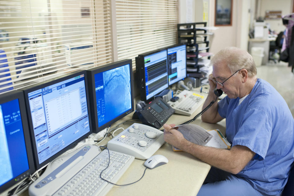 A nurse on the phone in front of computer screens