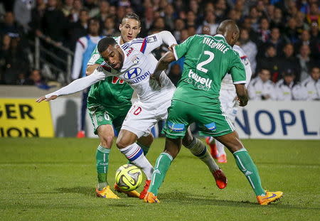 Olympique Lyon's Alexandre Lacazette (L) challenges Saint-Etienne's Jeremy Clement (C) and Kevin Theophile-Catherine (R) during their French Ligue 1 soccer match at the Gerland stadium in Lyon April 19, 2015. REUTERS/Robert Pratta