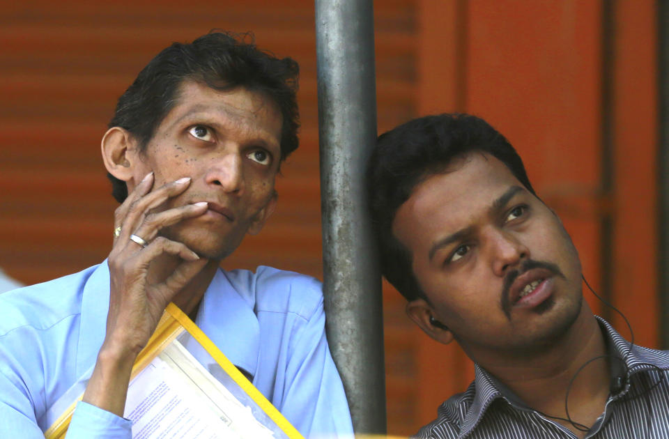 People watch a display screen on the facade of the the Bombay Stock Exchange (BSE) building in Mumbai , India, Monday Feb. 17, 2014. India's Finance Minister P. Chidambaram has unveiled a conservative budget for the government’s remaining time in office through May in parliament. (AP Photo/Rafiq Maqbool)