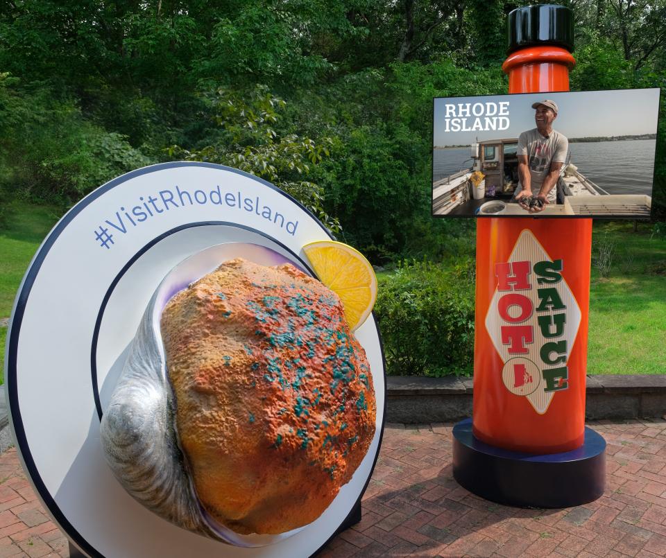 Airport installations depicting a giant stuffed clam and an 8-foot bottle of hot sauce are part of a marketing campaign to draw tourists to Rhode Island.