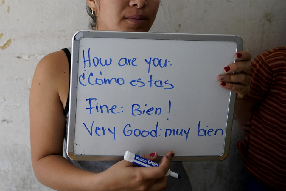 Gabriela Fajardo, a 26-year-old Honduran seeking asylum in the United States, teaches a Zoom class for Central American children living in camps, various shelters and apartments in other parts of Mexico from a hallway of an aged building on Friday, Nov. 20, 2020, in Matamoros, Mexico. Like countless schools, the sidewalk school went to virtual learning amid the coronavirus pandemic but instead of being hampered by the change, it has blossomed. (AP Photo/Eric Gay)