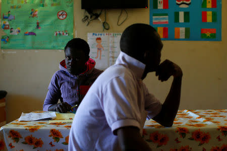 Adolescent migrants study at an immigration centre in the Sicilian town of Caltagirone, Italy April 20, 2016. REUTERS/Tony Gentile