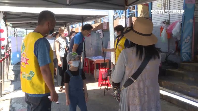 布袋觀光漁市場湧現人潮，遊客排隊量體溫等待入場。