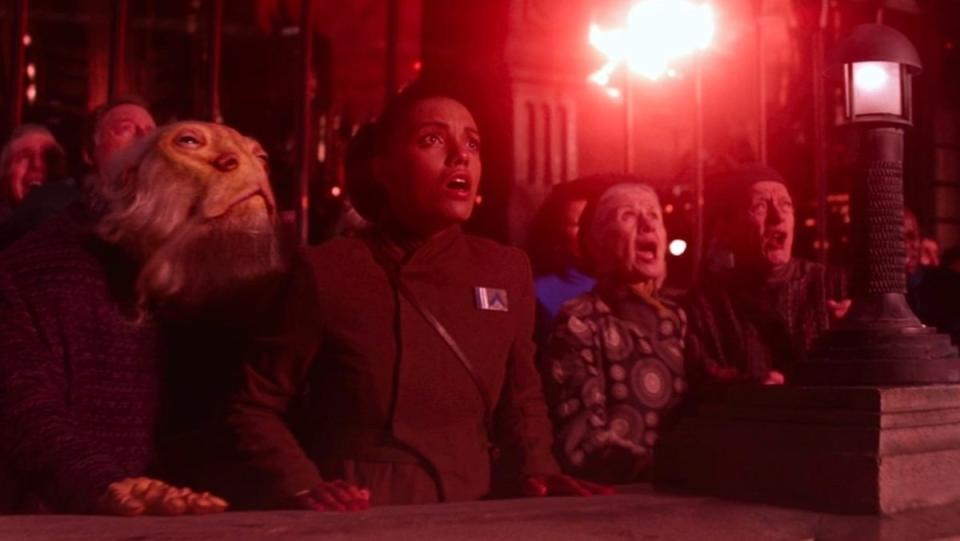 Scared citizens look on in terror as Starkiller Base destroys their planet in red light in The Force Awakens