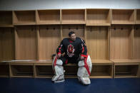 A member of the "1979" hockey club sits in the locker room before a match at a hockey rink in Beijing, Wednesday, Jan. 12, 2022. Spurred by enthusiasm after China was awarded the 2022 Winter Olympics, the members of a 1970s-era youth hockey team, now around 60 years old, have reunited decades later to once again take to the ice. (AP Photo/Mark Schiefelbein)