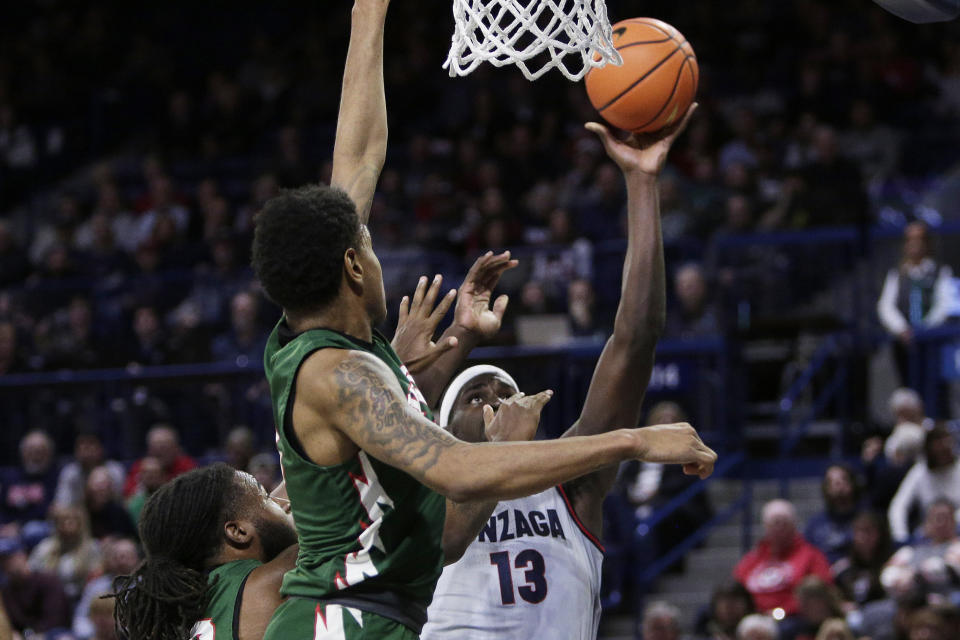 Gonzaga forward Graham Ike (13) shoots while pressured by Mississippi Valley State guard Rayquan Brown, center, and forward Reginald Reynolds, left, during the first half of an NCAA college basketball game, Monday, Dec. 11, 2023, in Spokane, Wash. (AP Photo/Young Kwak)