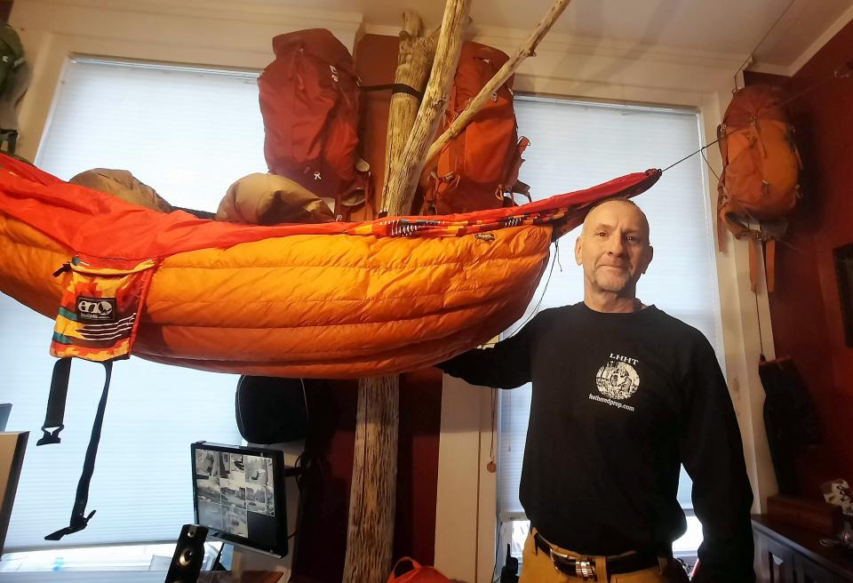 Dane Cramer of Somerset stands with his hammock and hanging backpacks in his home office. He enjoys hiking and camping throughout the year, including in the heart of winter.