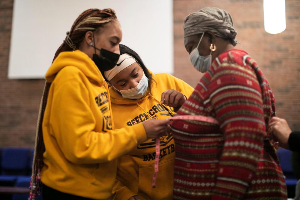 Beechcroft High School seniors, Saraia Fisher, center, and Alese McNair, left, both 17, help fit Nma Tambedu, 59, for a free bra at the Church of the Good Shepherd Free Store on Friday.