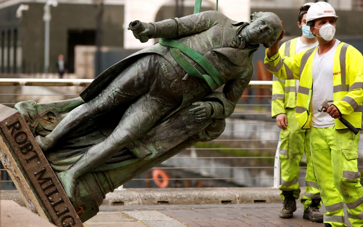 A statue of Robert Milligan is pictured being removed by workers outside the Museum of London Docklands near Canary Wharf - Reuters