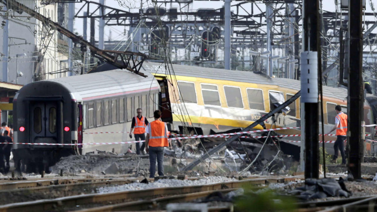 (Sur cette photo d’archive prise le 12 juillet 2013, des sauveteurs travaillent sur le site d’un accident de train dans la gare de Bretigny-sur-Orge près de Paris. Au moins sept personnes sont mortes et des dizaines ont été blessées après qu’un train roulant à grande vitesse s’est divisé en deux et a déraillé dans une gare de la banlieue sud de Paris, ont indiqué des responsables. - Neuf ans après la catastrophe ferroviaire de Bretigny-sur-Orge (Essonne), le tribunal d’Evry prononcera le 26 octobre 2022 son jugement contre la SNCF, SNCF Réseau et un ancien cheminot. (Photo de Kenzo TRIBOUILLARD / AFP)