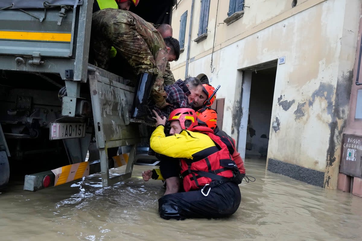 Firefighters rescue an elderly man in the flooded village of Castel Bolognese, Italy, in May (Copyright 2023 The Associated Press. All rights reserved)