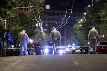 Forensics experts work at the scene after a bomb blast, in central Athens, Greece, April 19, 2017. REUTERS/Alkis Konstantinidis