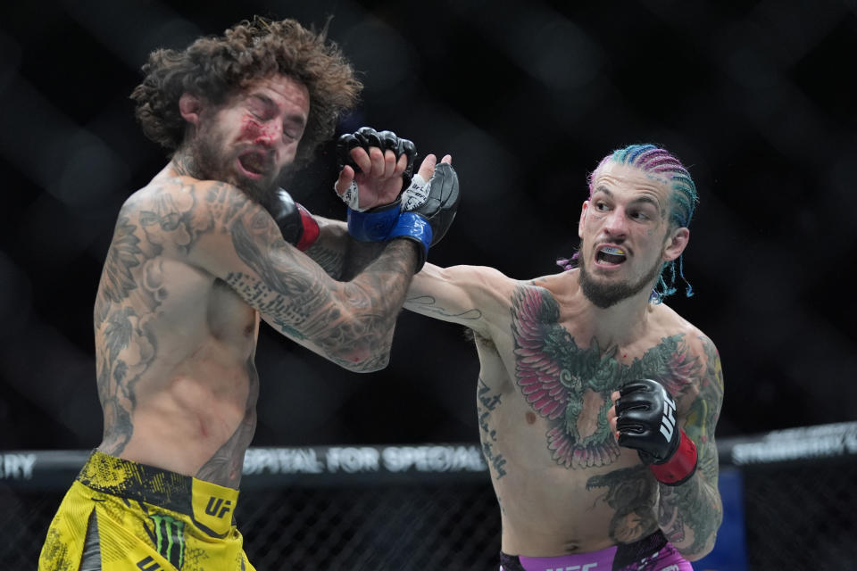 Sean O'Malley, right, lands a blow against Marlon Vera during a bantamweight title bout at the UFC 299 mixed martial arts event, early Sunday, March 10, 2024, in Miami. (AP Photo/Wilfredo Lee)
