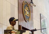 An Indian security guard stands at the gate of the Reserve Bank of India in Mumbai, India, Thursday, June 6, 2019. India's central bank has cut its key interest rate by a quarter of a percentage point to 5.75% from 6% with immediate effect to fortify the economy as consumer spending and corporate investment falter. (AP Photo/Rajanish Kakade)