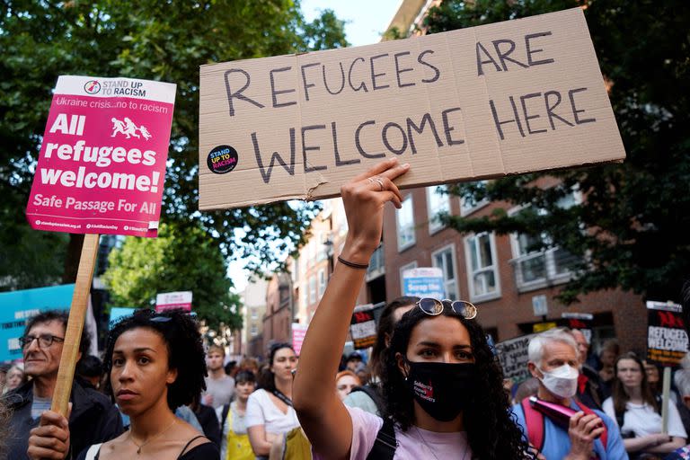 Unos manifestantes sostienen pancartas mientras se reúnen frente al Ministerio del Interior en el centro de Londres el 13 de junio de 2022, para manifestarse contra la intención del gobierno británico de deportar a solicitantes de asilo a Ruanda.