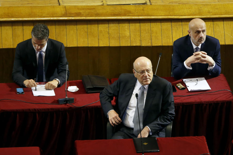 Lebanese Prime Minister Najib Mikati, center, attends a parliament session to confirm Lebanon's new government at a Beirut theater known as the UNESCO palace so that parliament members could observe social distancing measures imposed over the coronavirus pandemic, Lebanon, Monday, Sept. 20, 2021. A power outage and a broken generator briefly delayed the start of the parliament session for some 40 minutes before electricity came back on. (AP Photo/Bilal Hussein)