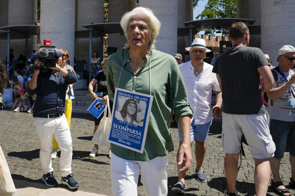 Pietro Orlandi wears a placard with a picture of his sister Emanuela as he arrives in St.Peter's Square prior to Pope Francis' Angelus noon prayer, at the Vatican, Sunday, June 25, 2023. The Pope in his speech remembered the 40th anniversary of the disappearance of Emanuela Orlandi, the 15-year-old daughter of a lay employee of the Holy See, that vanished June 22, 1983, after leaving her family's Vatican City apartment to go to a music lesson in Rome. (AP Photo/Andrew Medichini)