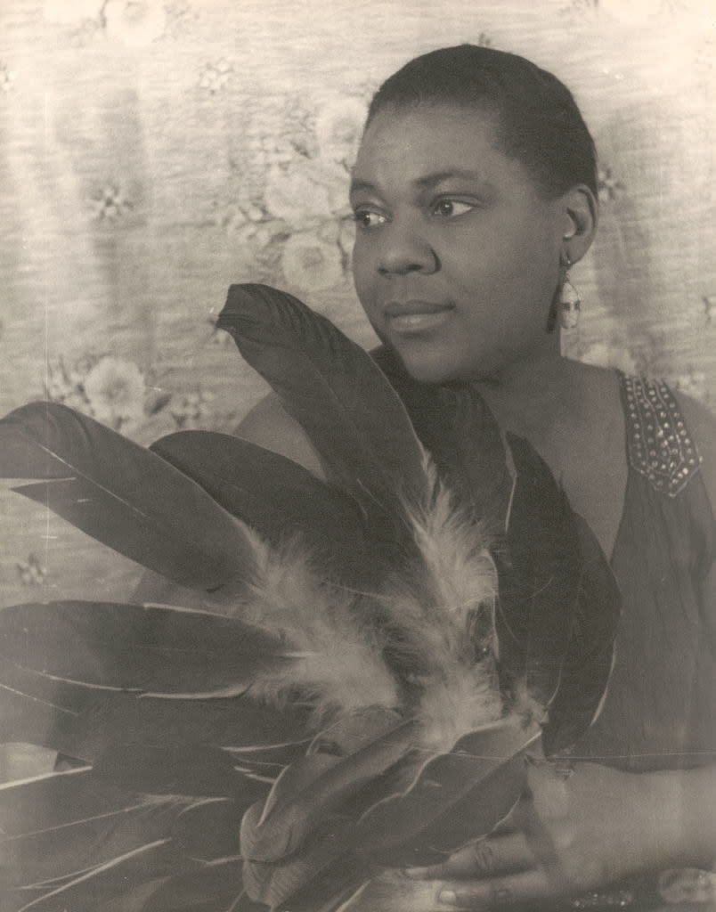 a portrait of Bessie holding a bundle of feathers
