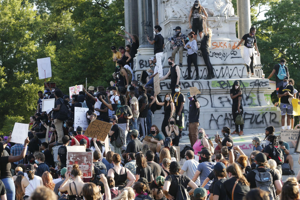 FILE - This Tuesday, June 2, 2020 file photo shows a large group of protesters gather around the statue of Confederate General Robert E. Lee on Monument Avenue near downtown in Richmond, Va. Virginia Gov. Ralph Northam announced plans Thursday, June 4, for the removal of the iconic statue. (AP Photo/Steve Helber, File)