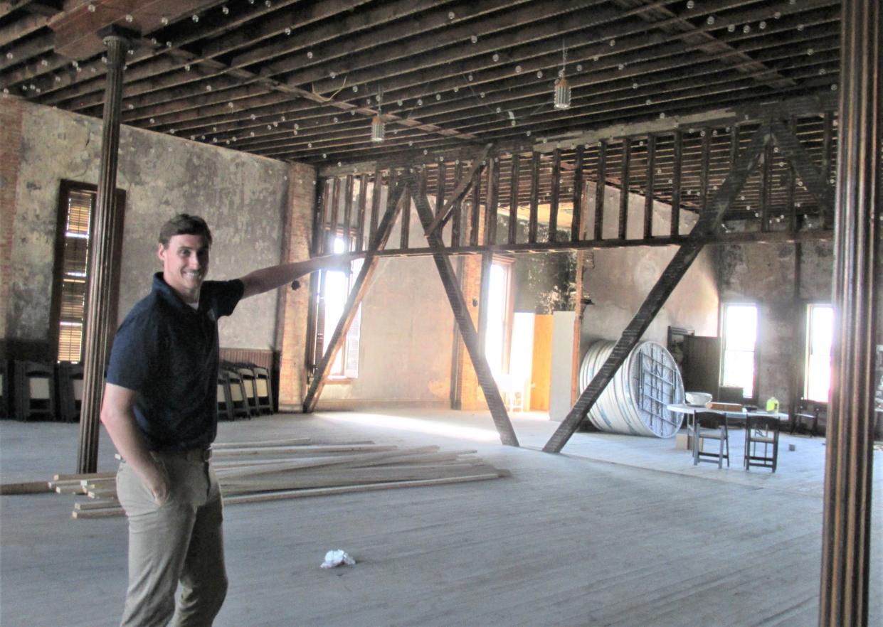 Dylan Kaufman points out the old wood structures that will be maintained as the third floor of the old American Hall building on the square in Millersburg undergoes a renovation. The one-time speakeasy will be a reception hall, possibly as soon as next summer.