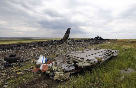 Pro-Russian separatists gather ammunition at the site of the crash of the Il-76 Ukrainian army transport plane in Luhansk, June 14, 2014. REUTERS/Shamil Zhumatov