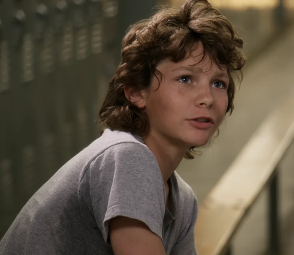 Georgie with a mullet in a locker room