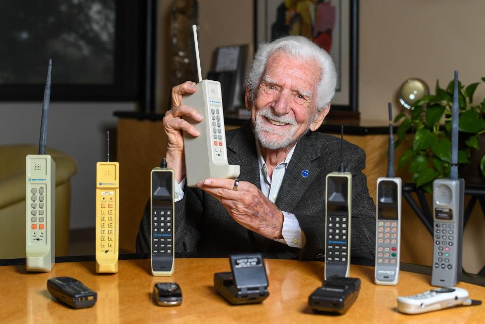 TOPSHOT - Engineer Martin Cooper holds a contemporary copy of the original cell phone he used to make the first cell phone call on April 3, 1973, in Del Mar, California on March 20, 2023. - The problem with mobile phones is that people look at them too much. At least, that's according to the man who invented them 50 years ago. Martin Cooper, an American engineer dubbed the "Father of the cell phone," says the neat little device we all have in our pockets has almost boundless potential and could one day even help conquer disease. But right now, we can be a little obssessed. (Photo by VALERIE MACON / AFP) (Photo by VALERIE MACON/AFP via Getty Images)