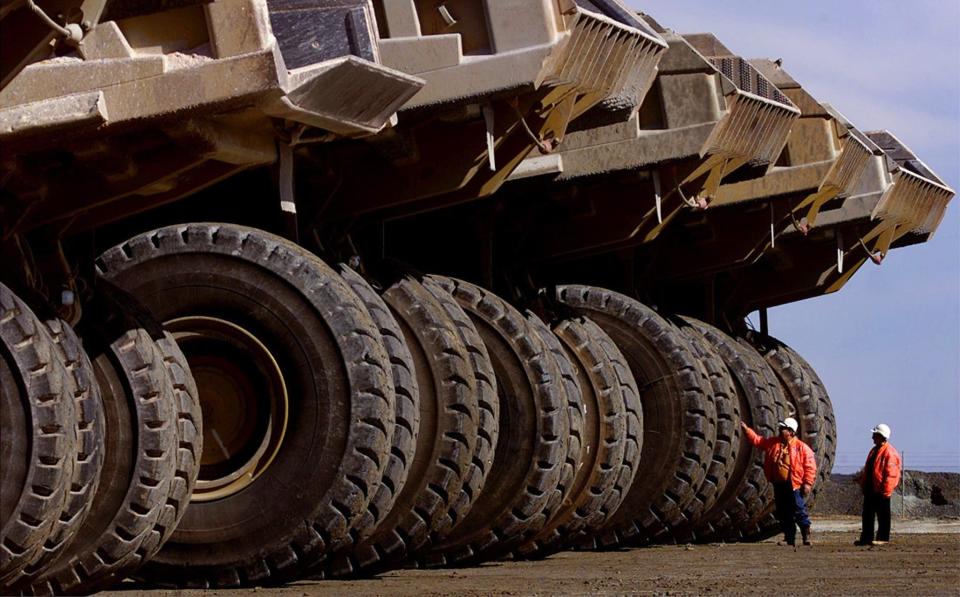 group of giant mining trucks at the largest open pit gold mine in Australia, near Kalgoolie - David Gray/Reuters