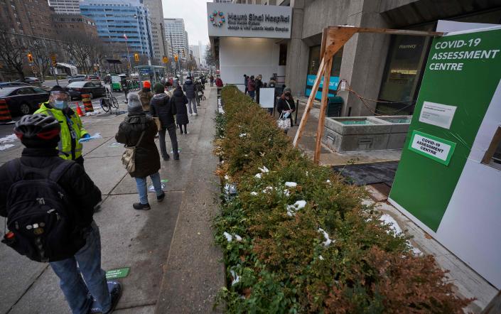 People line up outside a COVID testing site.