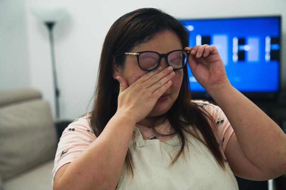 In this Wednesday, June 3, 2020 photo, Feby Cachero Baguisa Dela Pena of Laguna, Philippines, wipes away tears after becoming emotional while talking about challenges in her life amid her effort to hand out free food to those who need it in Dubai, United Arab Emirates. Dela Pena, a mother of three, is unemployed, but when she saw people lining up for free meals one night outside her building two weeks ago she decided to use whatever money her family had to help out the countless numbers of Filipinos and others who've lost jobs amid the coronavirus. (AP Photo/Jon Gambrell)