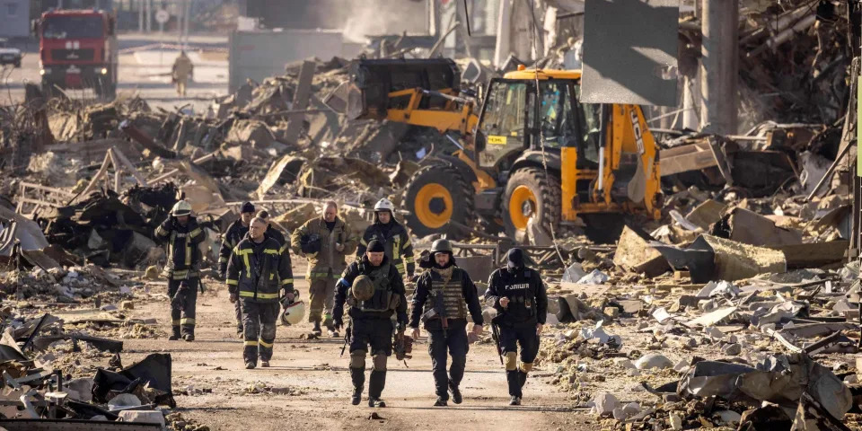 Ukrainian firefighters work amid the rubble of the Retroville shopping mall, a day after it was shelled by Russian forces in a residential district in the northwest of the Ukranian capital Kyiv on March 21, 2022. - At least six people were killed in the bombing. Six bodies were laid out in front of the shopping mall, according to an AFP journalist. The building had been hit by a powerful blast that pulverised vehicles in its car park and left a crater several metres wide. (Photo by FADEL SENNA / AFP) (Photo by FADEL SENNA/AFP via Getty Images)