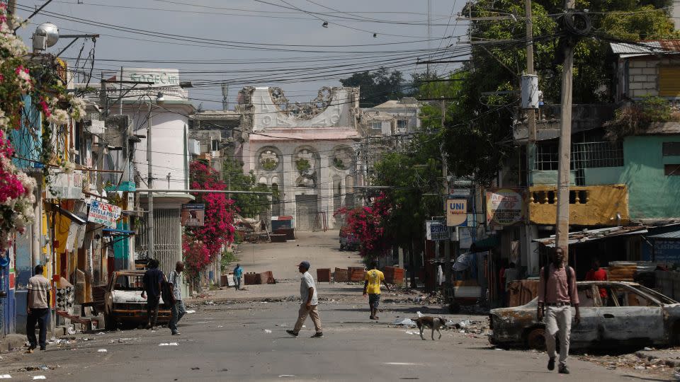 Pedestrians walk on an empty street near the earthquake-destroyed Cathedral in Port-au-Prince, Haiti, Monday, March 25, 2024. - Odelyn Joseph/AP