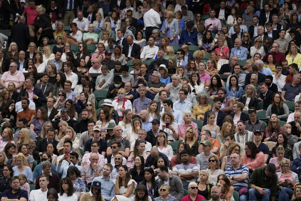 Spectators watch the women's singles quarterfinals match between Tunisia's Ons Jabeur and Aryna Sabalenka of Belarus as the court opens to full capacity on day eight of the Wimbledon Tennis Championships in London, Tuesday, July 6, 2021. (AP Photo/Kirsty Wigglesworth)