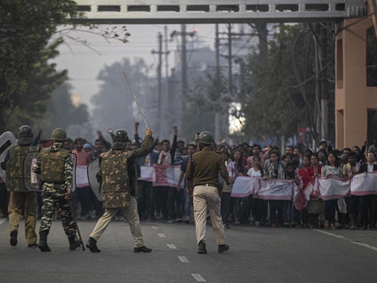 Indian police and paramilitary personnel stop protesters during a curfew in Gauhati: AP