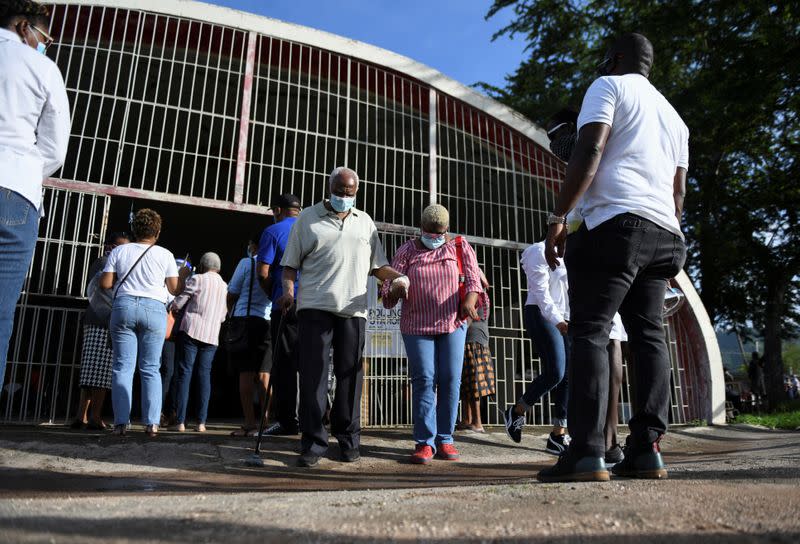 People stand in line to cast their votes in the general elections, in Kingston