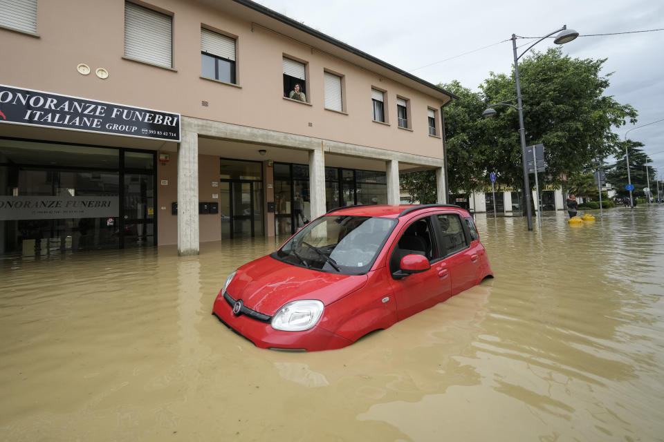 A car lies on a flooded street in the village of Castel Bolognese, Italy, Wednesday, May 17, 2023. Exceptional rains Wednesday in a drought-struck region of northern Italy swelled rivers over their banks, killing at least eight people, forcing the evacuation of thousands and prompting officials to warn that Italy needs a national plan to combat climate change-induced flooding. (AP Photo/Luca Bruno)